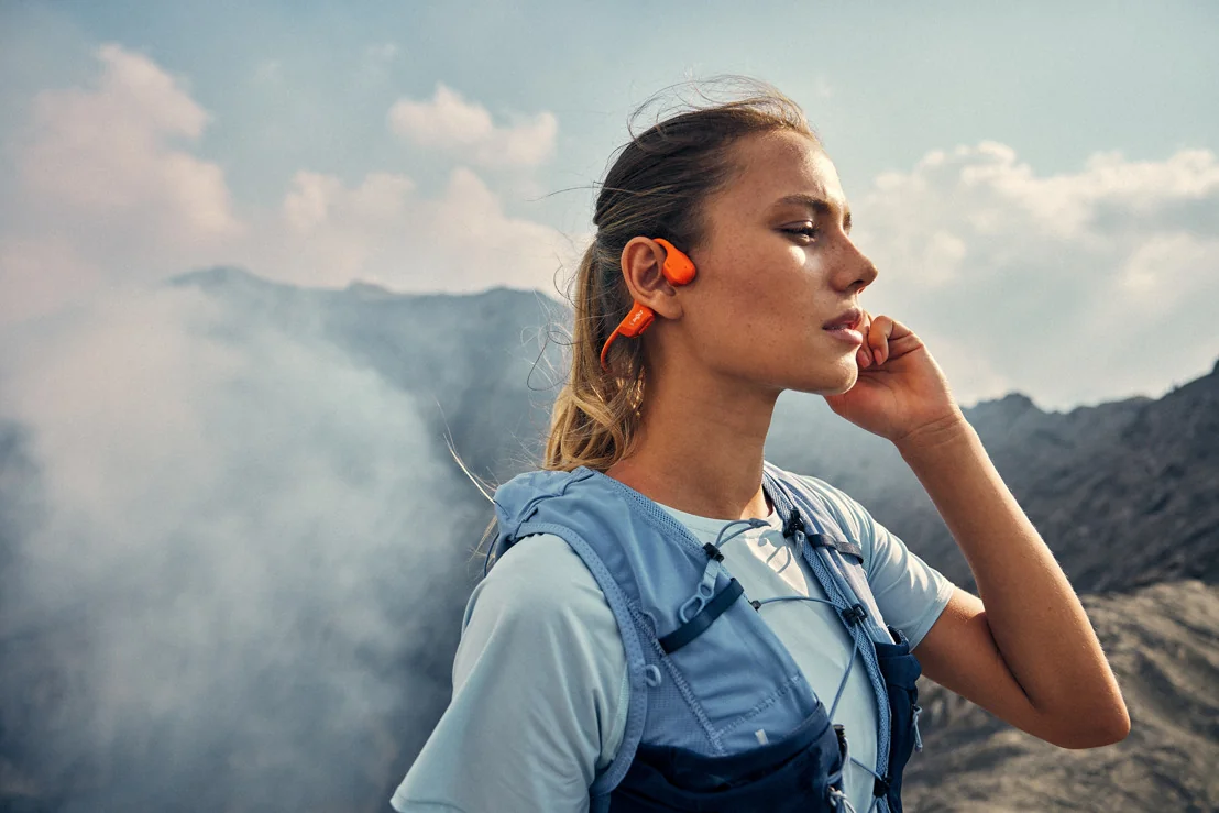 Le casque Shokz OpenRun Pro 2 orange porté lors d'une sortie en montagne.